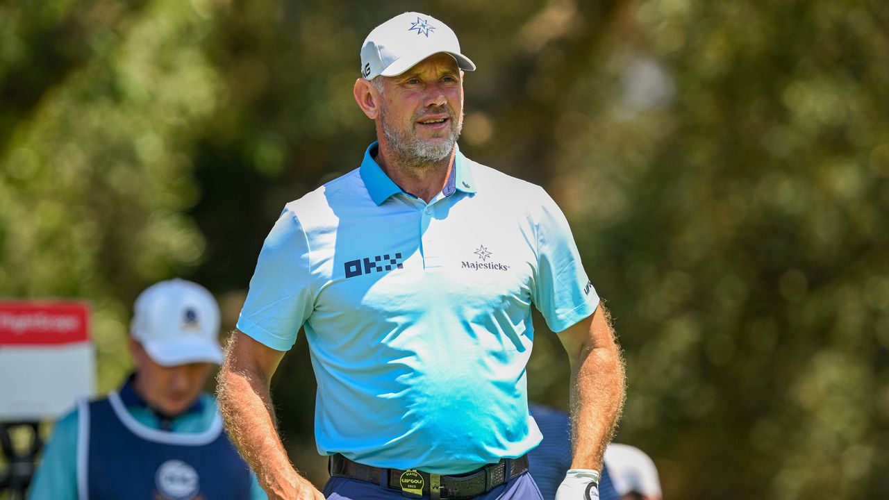 Lee Westwood wearing a sky blue polo shirt while playing golf