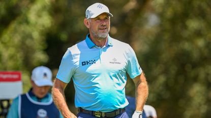 Lee Westwood wearing a sky blue polo shirt while playing golf
