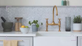 clean neutral kitchen with a white butler sink iwth brass tap to support gudienace for cleaning countertops and drains for how to get rid of fruit flies