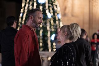 Dom (Steve Edge) and Jean (Sally Lindsay) stand in the town square of Sainte Victoire, with a huge lit-up Christmas tree in the background behind them