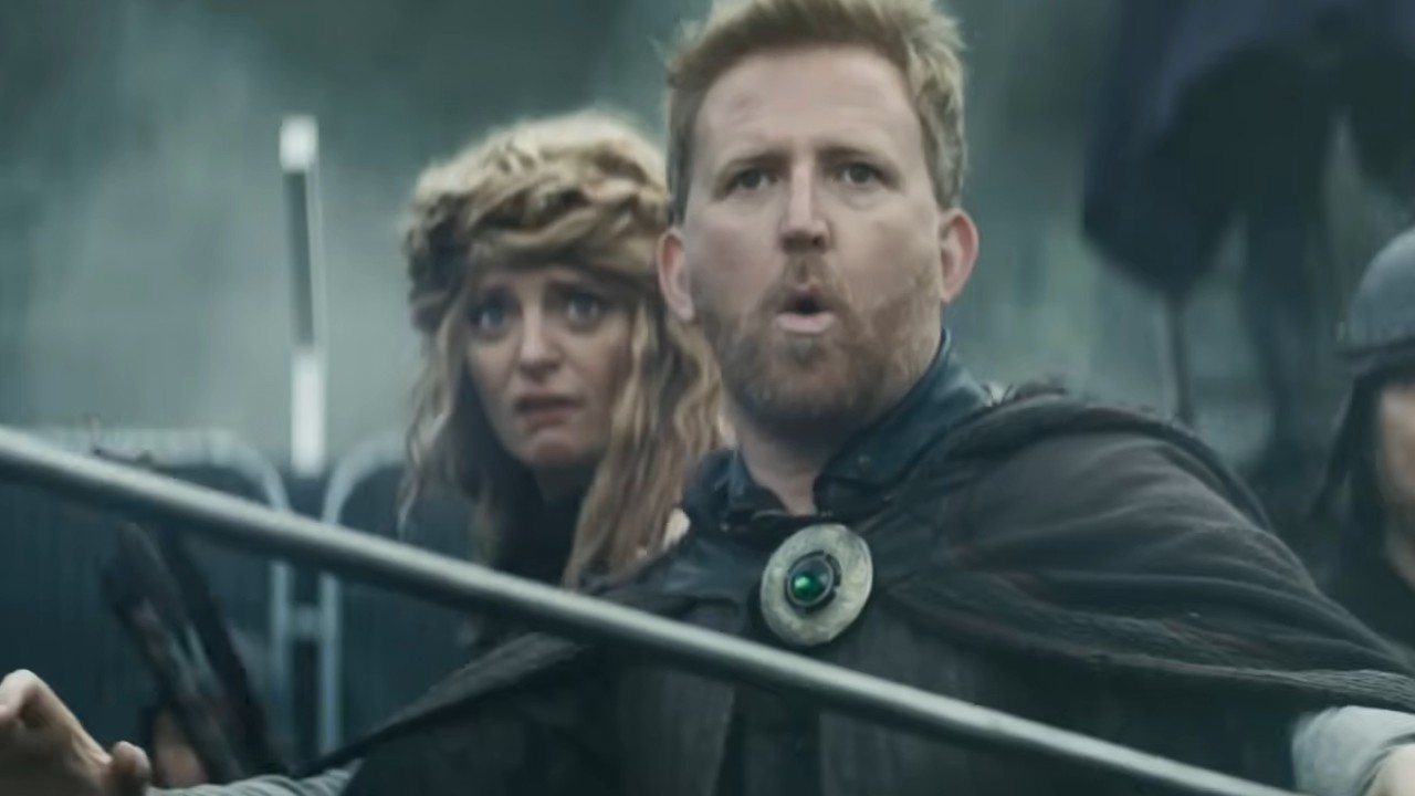 Tom Goodman-Hill surprised in Robin and the Hoods. Morgana Robinson stands behind him.