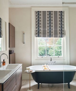 Blue bath in beige bathroom with patterned blind