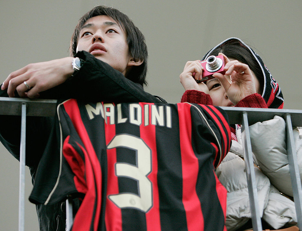 Japanese fans watch as Italian football club AC Milan players practice as they display a jersey of defender Paolo Maldini in Yokohama