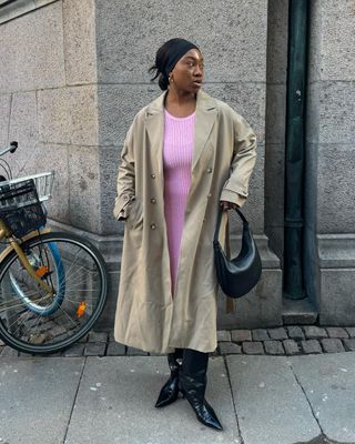 12 Scandi Outfit Ideas: Nnenna wears a pink midi dress with trench coat and boots