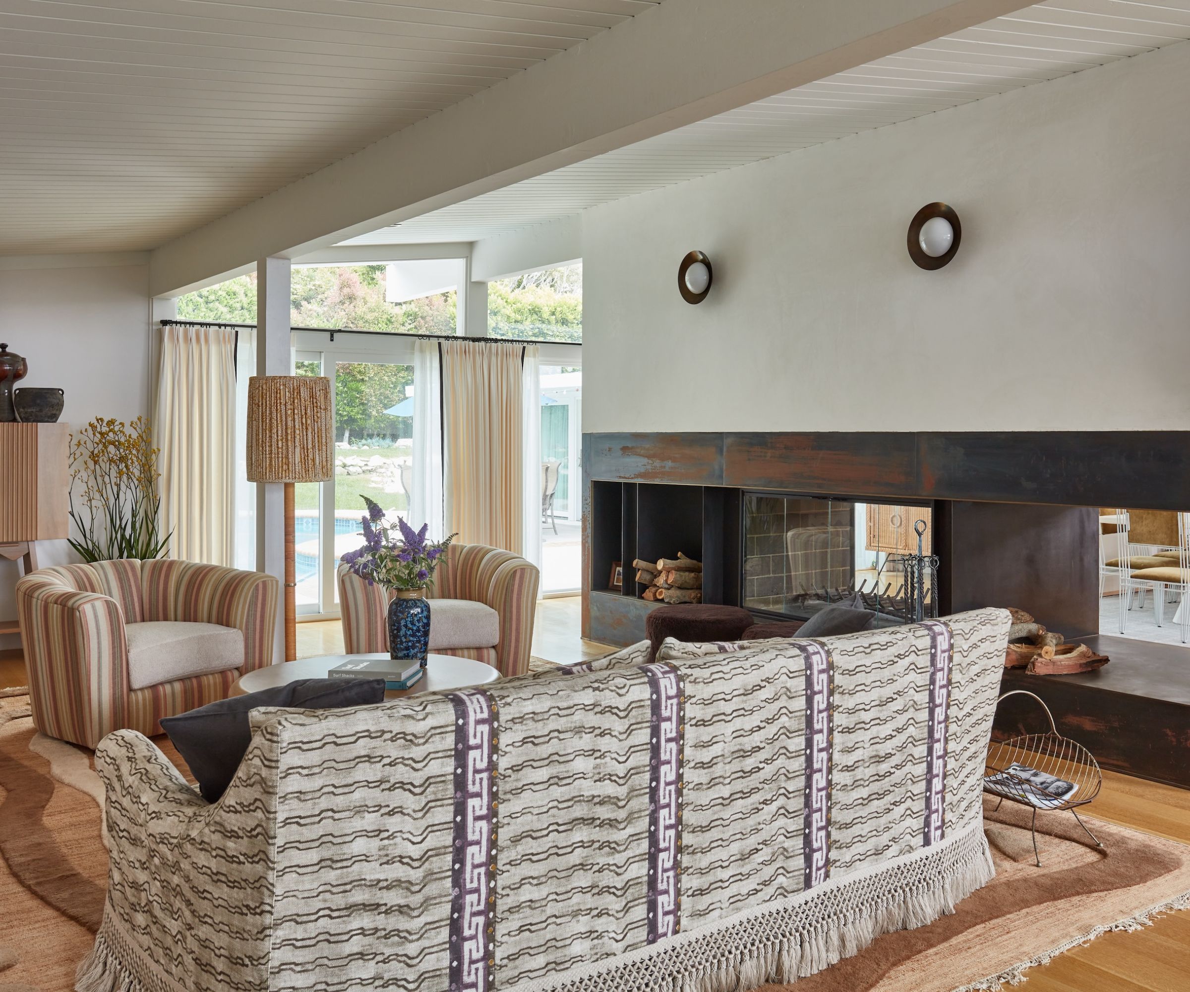 living room with an earthy neutral color palette, white walls and a patterned sofa and armchairs