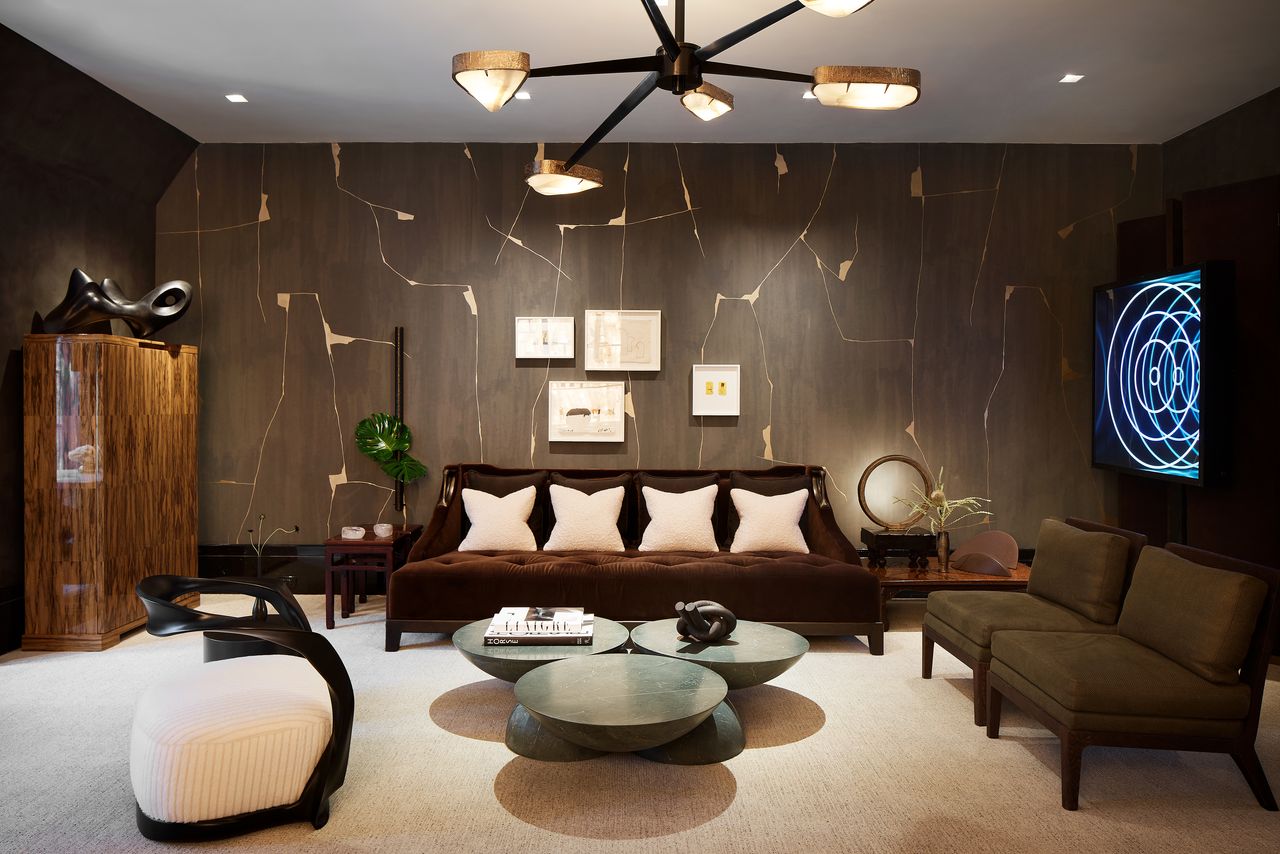 A living room with brown wood-effect walls, a brown sofa with cream cushions, and wooden furniture 