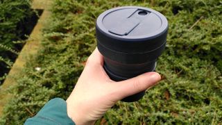 Woman's hand holding silicone coffee cup
