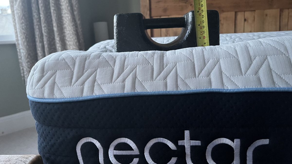 56lbs weight on the edge of nectar classic hybrid mattress with tape measure to test edge support