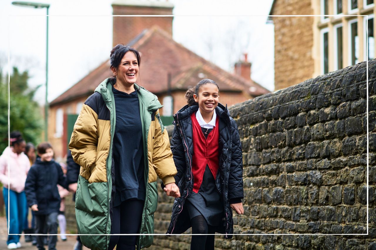 Smiling mother walking her daughter to school