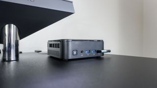 The Kamrui E3B mini PC on the edge of a desk