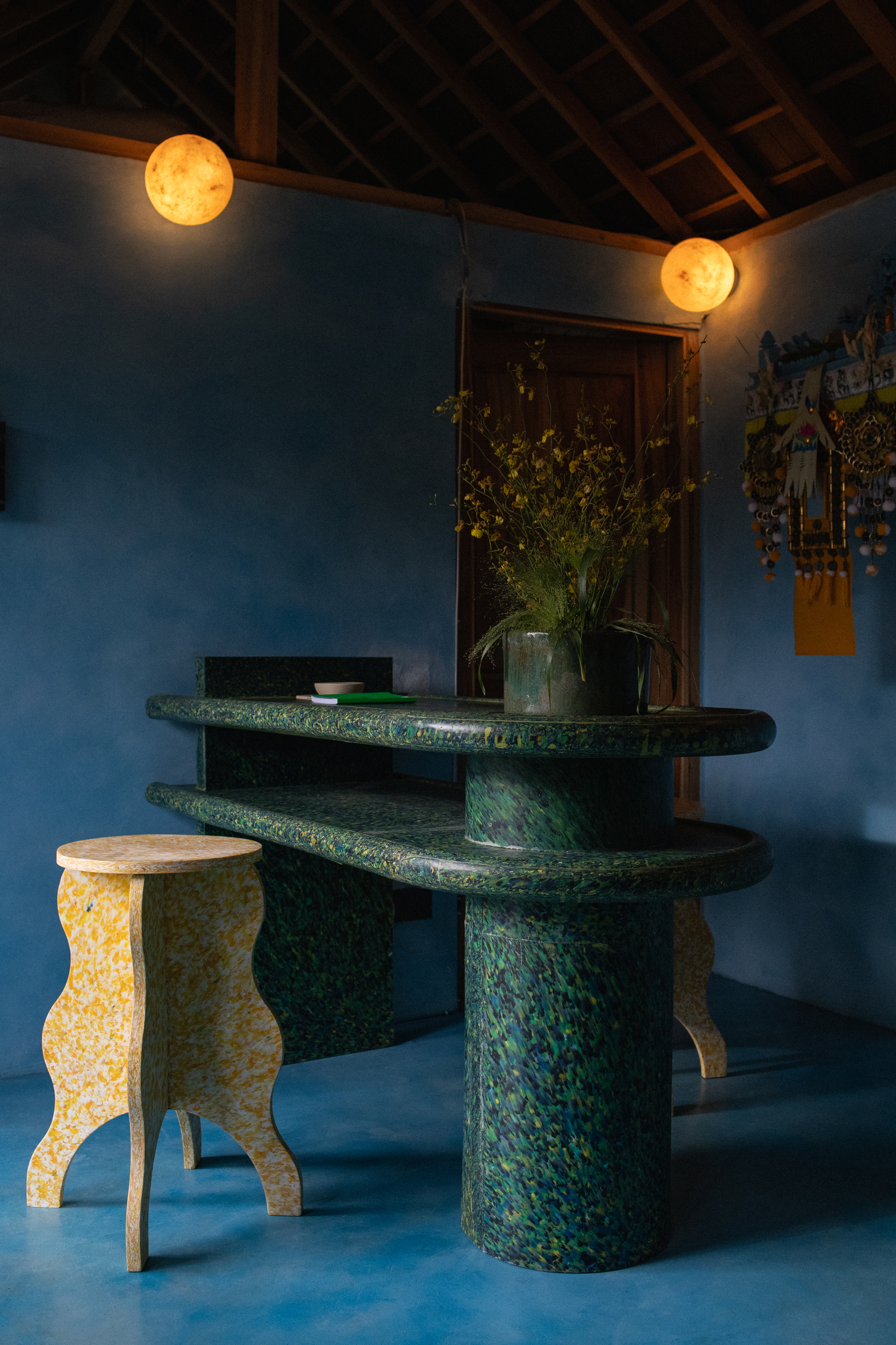 Interiors of a tropical interiors with curved passageways, terracotta walls, colorful curtains, woody furniture, color pops, and nature all around.