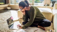 girl sat on the floor studying/managing money