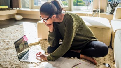 girl sat on the floor studying/managing money