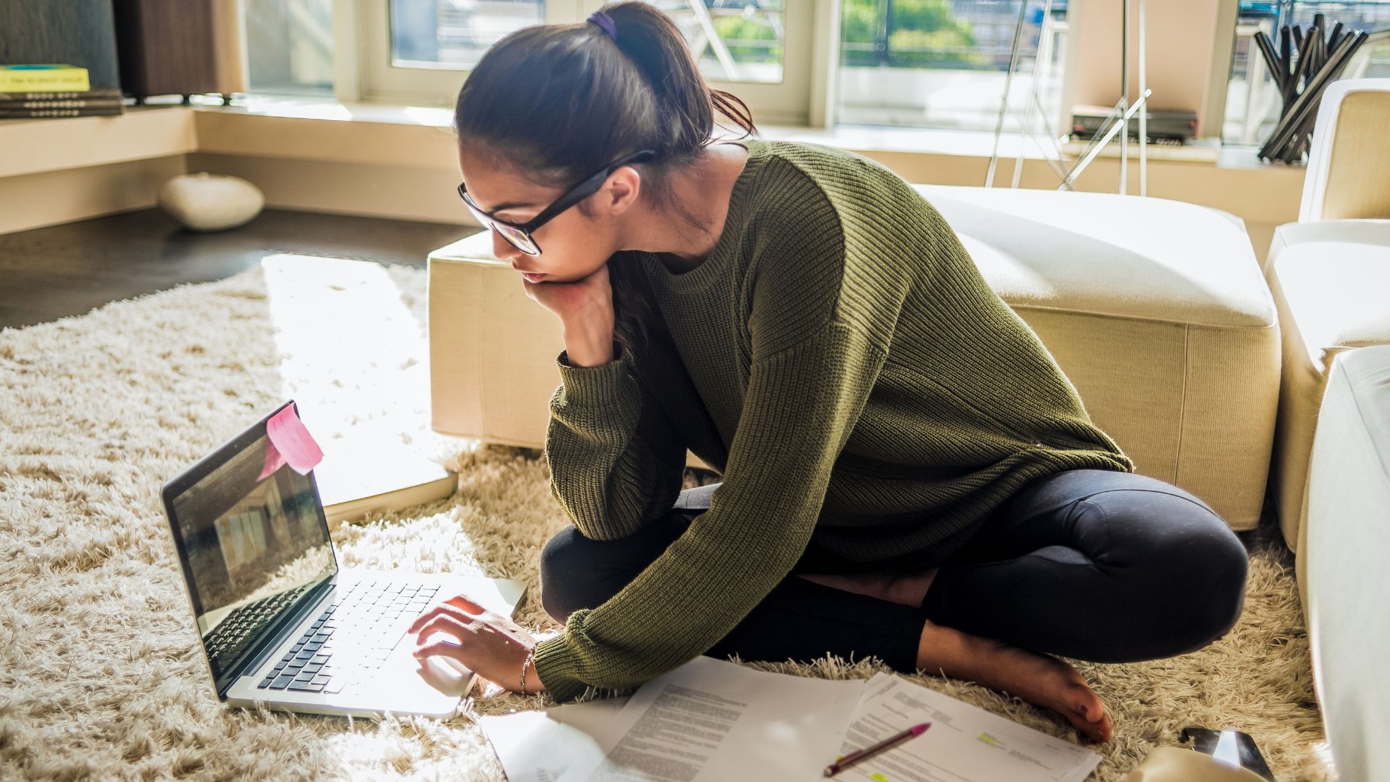 girl sat on the floor studying/managing money