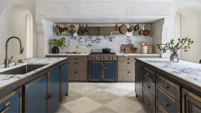 A kitchen with marble splashback that goes up the wall