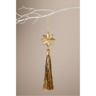 Gold christmas tree ornament with a star and hanging tinsel