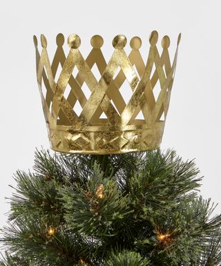 An unlit metal crown-shaped Christmas tree topper in gold