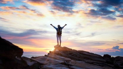 A man reaching the top of the mountain