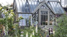 A grand greenhouse surrounded by flower-filled beds at the Chelsea Flower Show