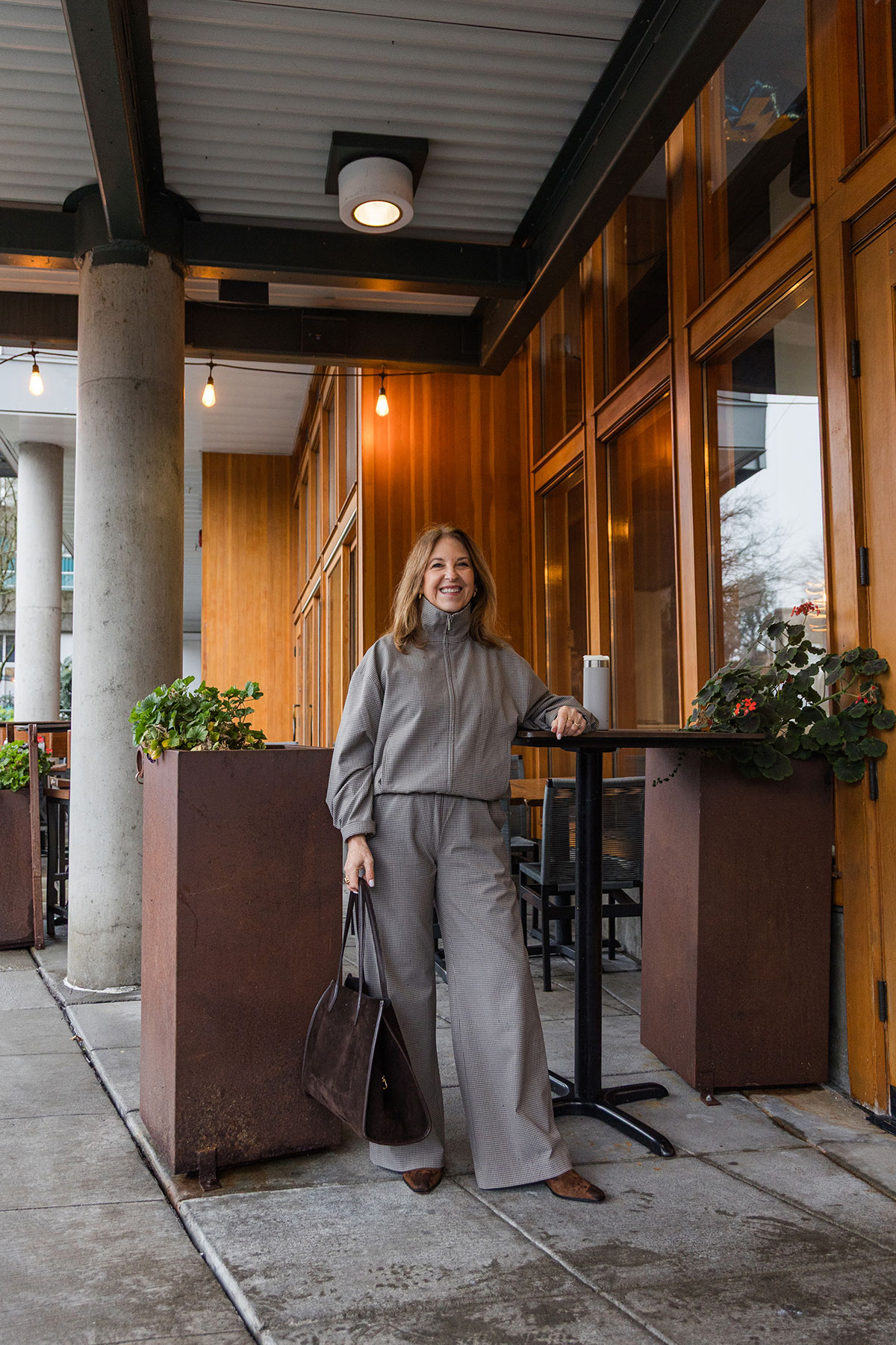 A former Nordstrom stylist wearing a funnel-neck jacket and matching track pants.