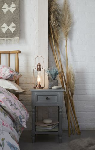 Bedside table with copper hurricane light from Dunelm