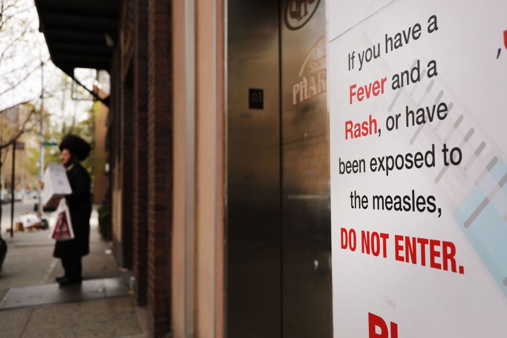 A sign in Brooklyn, New York, where there is currently a measles outbreak, warns people not to enter a building if they have symptoms of the disease.