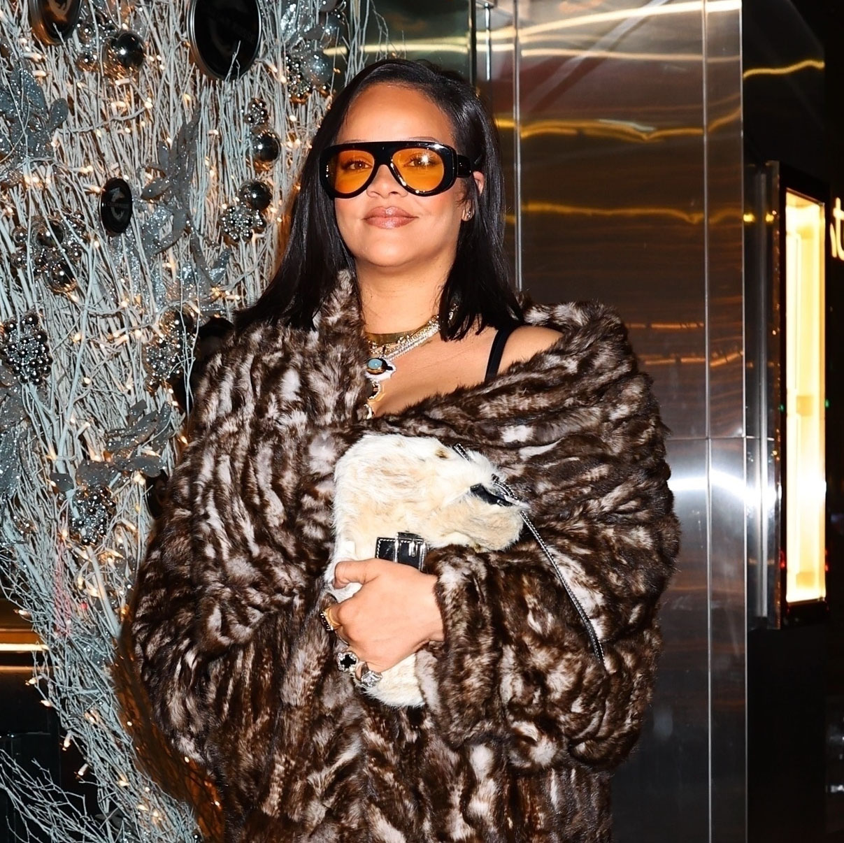 Rihanna wearing a fur coat, brown Loewe pants, and croc print heels