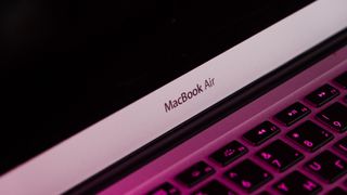 A closeup of a MacBook Air logo on a laptop.