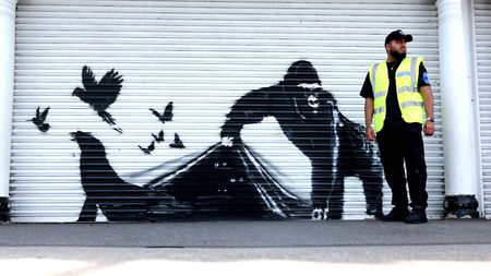 An artwork by Banksy depicts a gorilla releasing animals on the front of a shutter outside London Zoo 