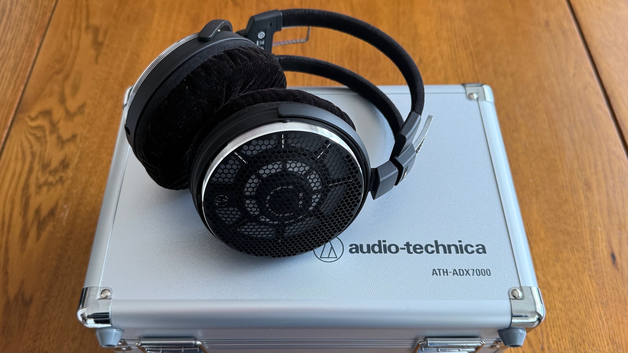 Photos of the Audio-Technica ATH-ADX7000 headphones on a wooden table