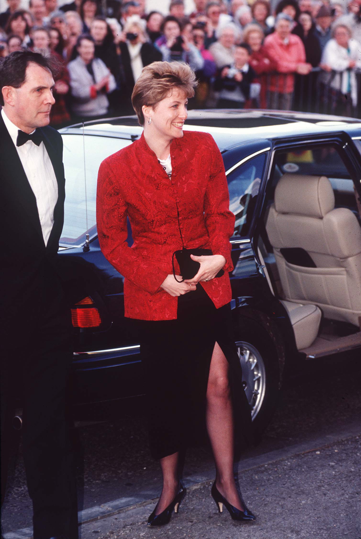 Duchess Sophie getting out of a car wearing a red blazer and black skirt with a slit