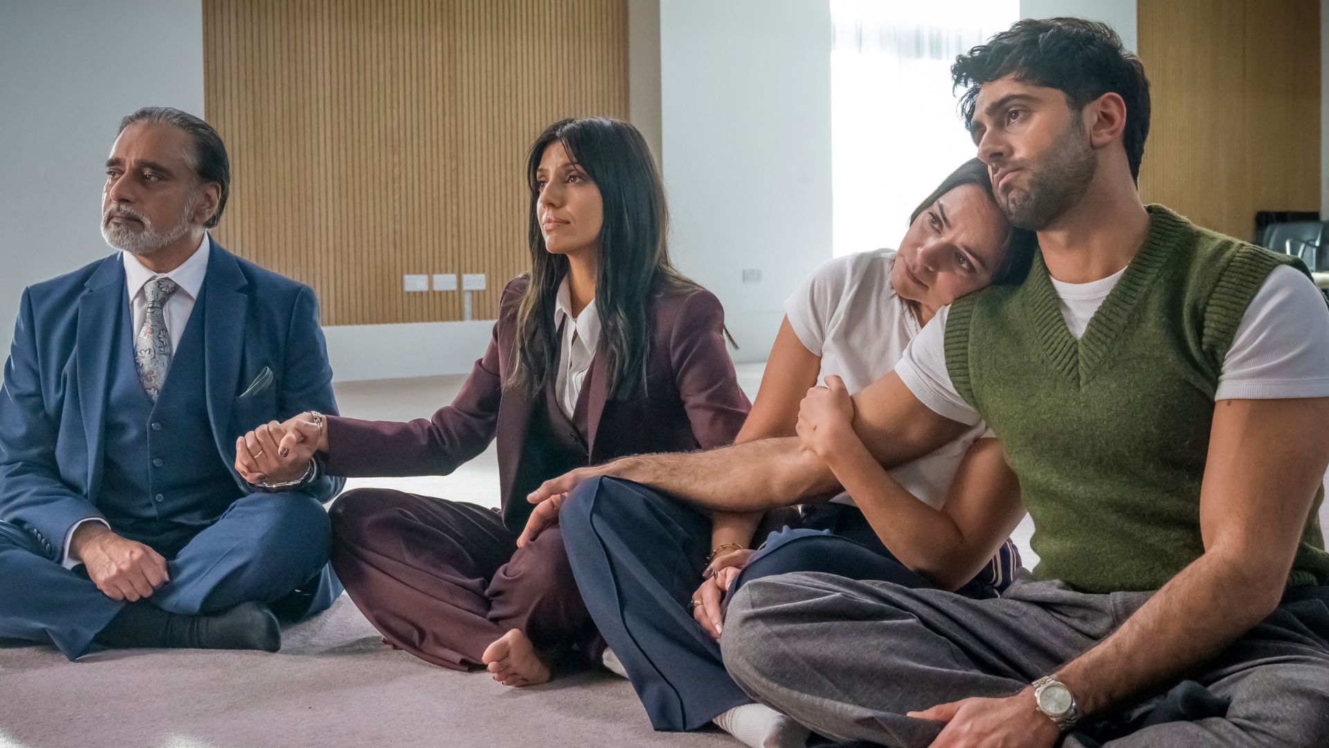 The Kishan family sit cross-legged on the floor