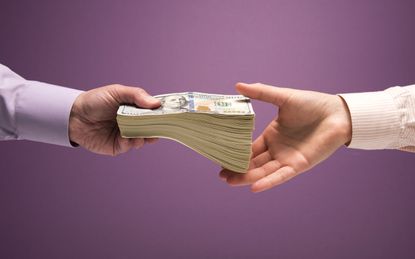 One man and one woman's hands handing off large stack of US 100 bills, purple background