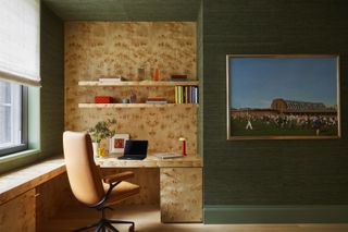 A guest bedroom with green walls and a built-in burl wood desk