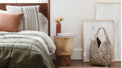 Mona Basket in black and natural beside bed with jute rug, wooden bedside table and dark wood bed