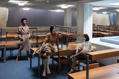 Three women sit in archive Akris in Brutalist library