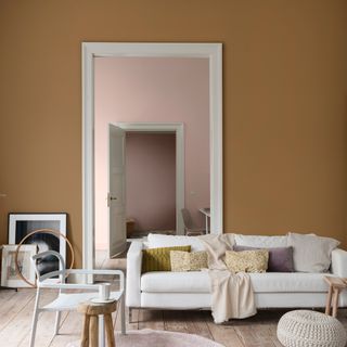 A living room with honey brown walls and white doorframe with white sofa