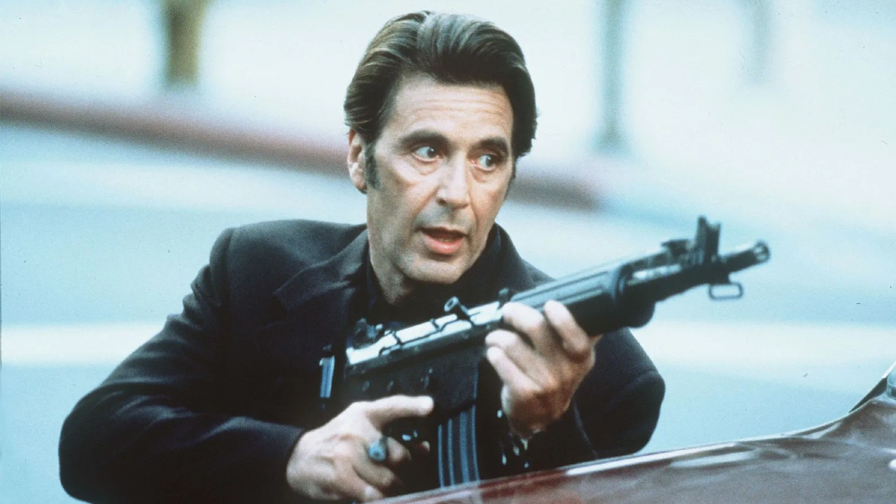 A still image of Al Pacino holding an assault rifle in the film Heat