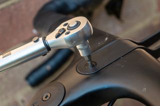 An M Part torque wrench and hex bits in a case on a concrete floor