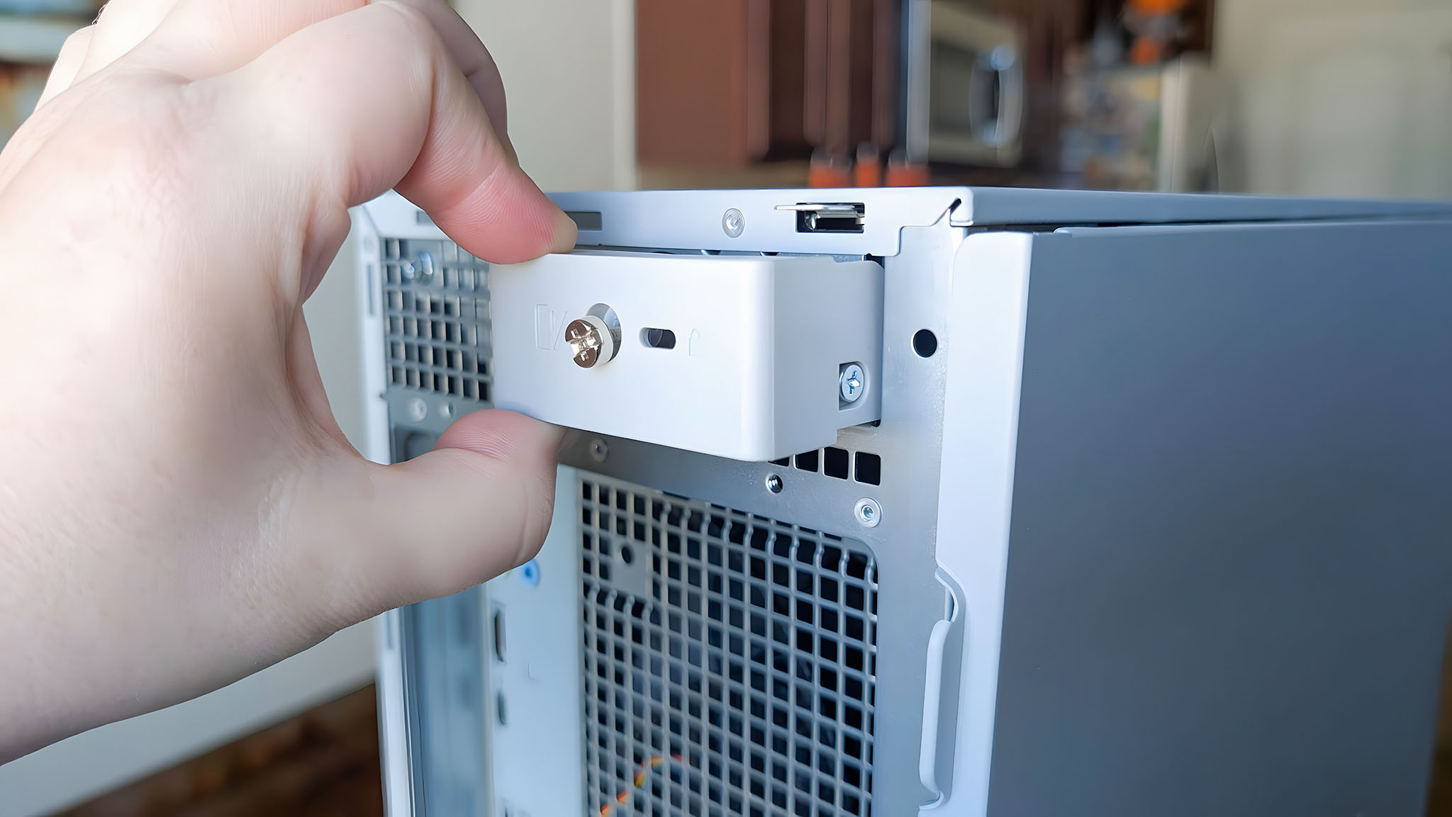 A hand pulling open the panel lock on the back of the Dell Tower Plus EBT2250.