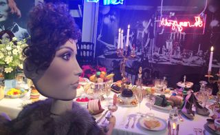 Mannequin head and body sitting at a decorated table