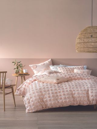 Pink bedroom with pom pom bedding and pink colour block walls