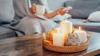 A woman sits behind some candles