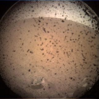 This photo is the first image of Mars taken by NASA's InSight Mars lander after its successful landing on the plains of Elysium Planitia on Nov. 26, 2018. The dust seen in the image is on a dust cover protecting the camera.