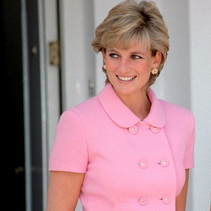 Princess Diana wearing a short-sleeved suit jacket smiling and looking to the left