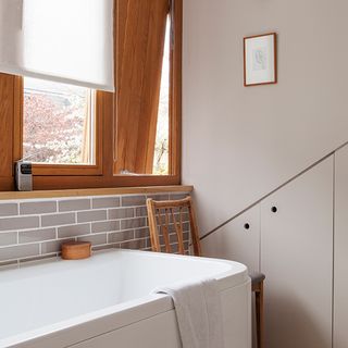 bathroom with white bathtub and wooden window
