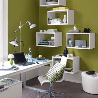 home office with green wall and laptop