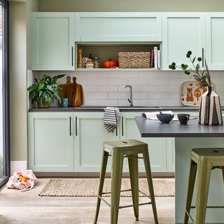 kitchen with green coloured and stools