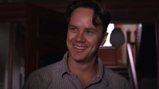 Tim Robbins smiling in a doorway in The Shawshank Redemption.