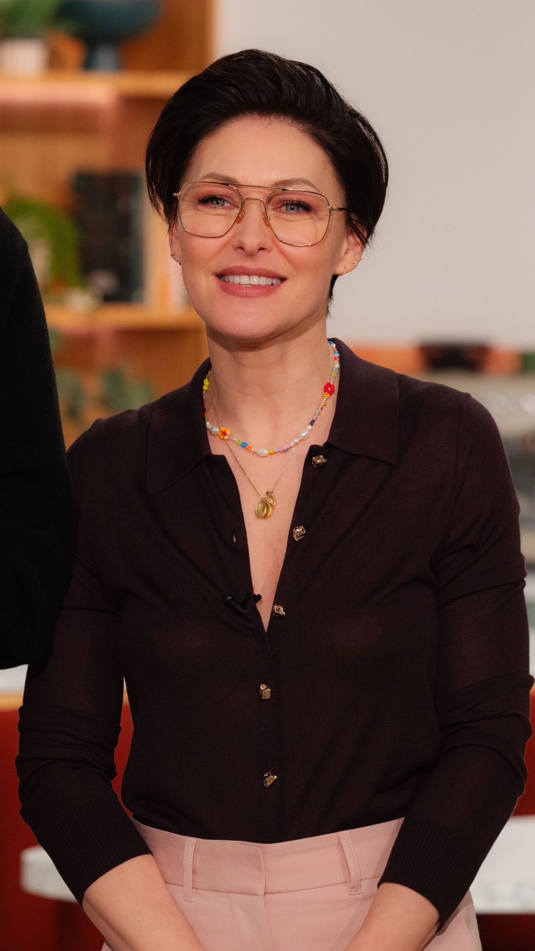 EMMA WILLIS WEARING A BROWN KNIT TOP